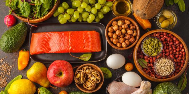 Elements of a Paleo diet, including fruits, salmon, poultry, nuts, eggs.